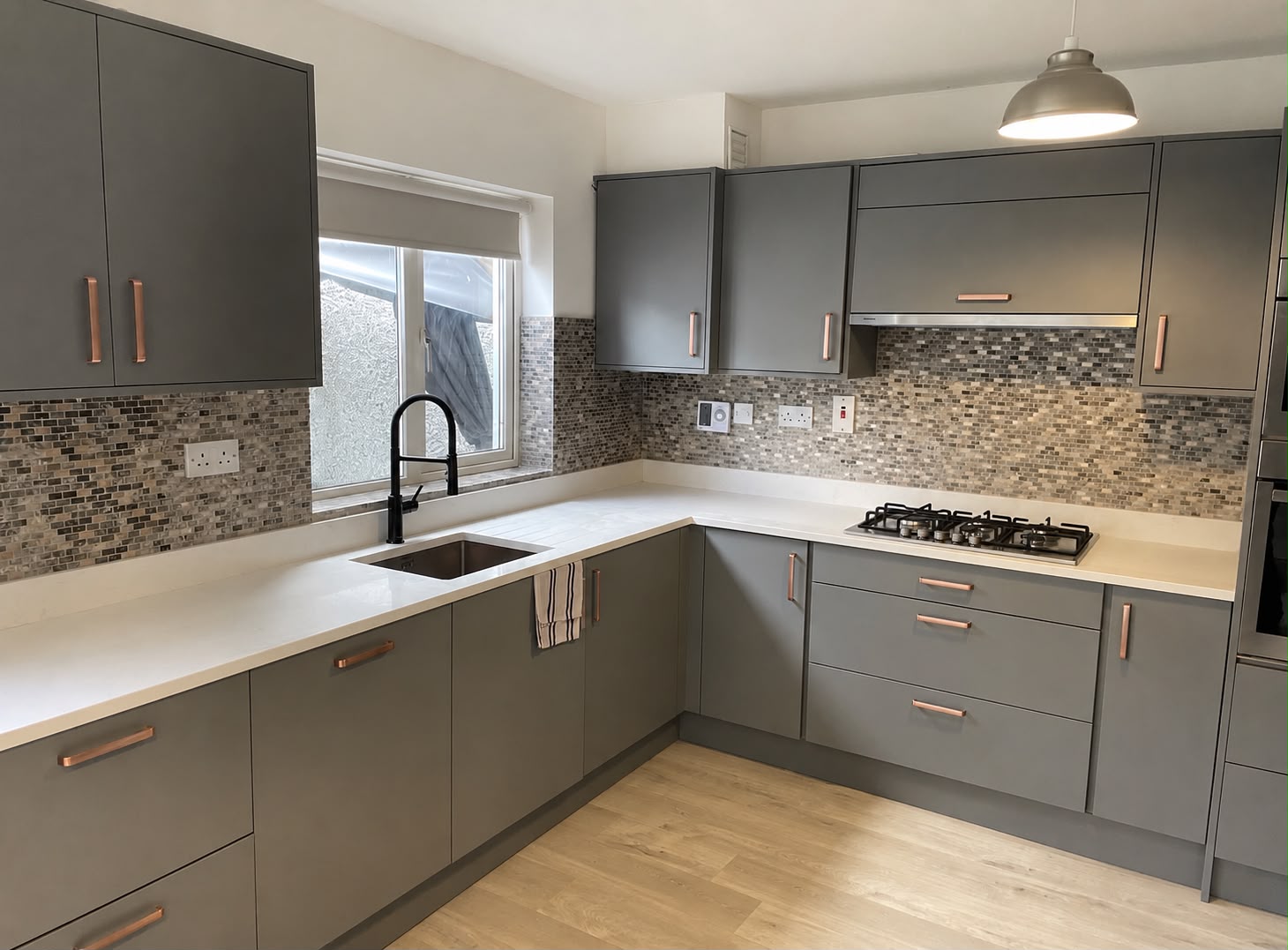 Modern grey shaker kitchen renovation with copper handles and mosaic tile splashback